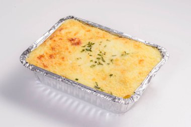 Lazanya teslimatı. Teslimat için paketlenmiş peynirli lazanya beyaz arka planda izole edilmiş..