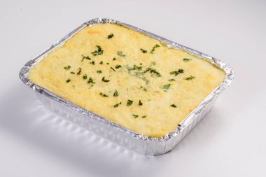 Lazanya teslimatı. Teslimat için paketlenmiş peynirli lazanya beyaz arka planda izole edilmiş..