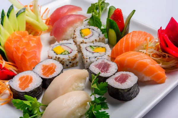 Japon yemeği karışımı, suşi ve beyaz tabakta sashimi..