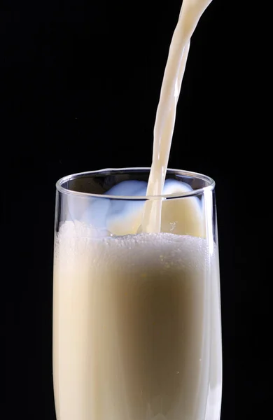 Melk Wordt Gegoten Glazen Beker Zwarte Achtergrond — Stockfoto