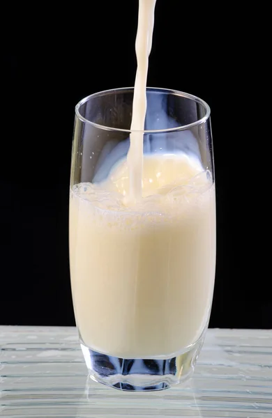 Milch Wird Glasbecher Auf Schwarzem Hintergrund Gegossen — Stockfoto