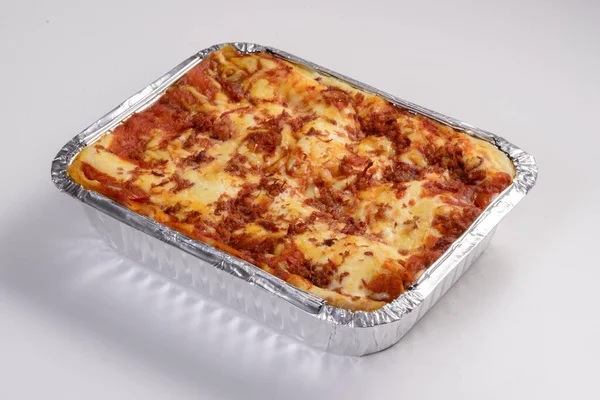 Lasagna delivery. Sun meat lasagna in packaging for delivery isolated on white background.