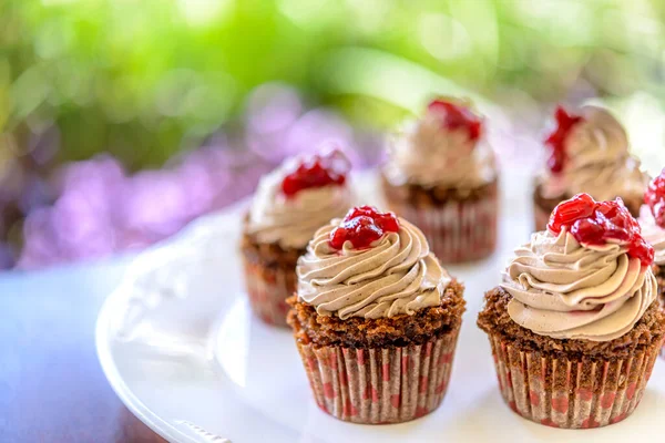 Cupcakes Weißem Teller Auf Holztisch Mit Verschwommenem Gartenhintergrund — Stockfoto