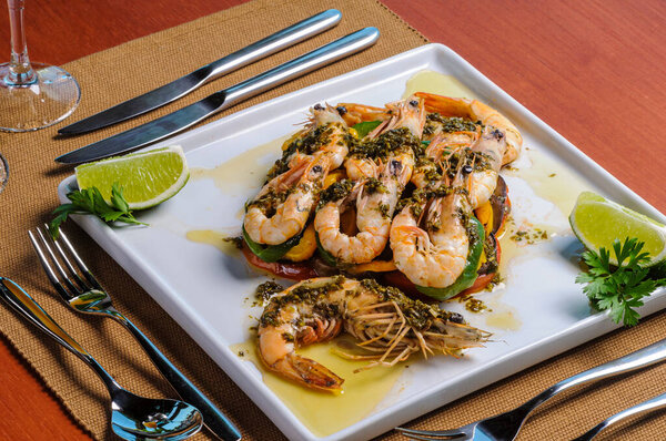 Shrimps with vegetables sauted in olive oil on a white square plate served at the table. — Stock Image Shrimps Vegetables Sauted Olive Oil White Square Plate Served Table Stock Picture