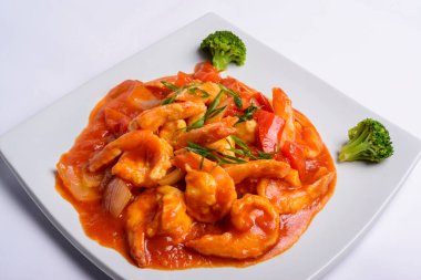 Beyaz kare tabakta domates soslu karides. - Yakın çekim. Çin yemeği..