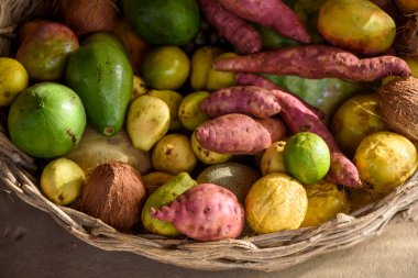 Organic Brazilian agricultural products in basket. Avocado, sweet potato, passion fruit, guava, lime, coconut and passion fruit.