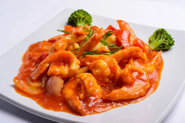 Beyaz kare tabakta domates soslu karides. - Yakın çekim. Çin yemeği..