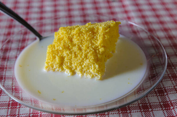 Corn couscous with milk on table with red and white tablecloth. Popular dish from the northeast region of Brazil, widely consumed for breakfast. — Stock Image Corn Couscous Milk Table Red White Tablecloth Popular Dish Northeast Stock Picture