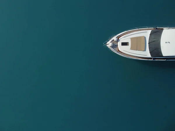 Aerial boat race. Luxury cruise trip. View from above of white boat on deep blue water. Aerial view of rich yacht sailing sea. Motor boat racing wave. Summer journey on luxury ship