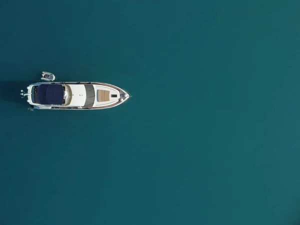 Aerial boat race. Luxury cruise trip. View from above of white boat on deep blue water. Aerial view of rich yacht sailing sea. Motor boat racing wave. Summer journey on luxury ship