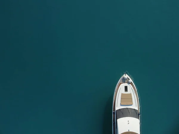 Aerial boat race. Luxury cruise trip. View from above of white boat on deep blue water. Aerial view of rich yacht sailing sea. Motor boat racing wave. Summer journey on luxury ship