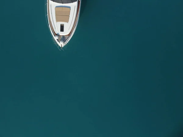 Aerial boat race. Luxury cruise trip. View from above of white boat on deep blue water. Aerial view of rich yacht sailing sea. Motor boat racing wave. Summer journey on luxury ship