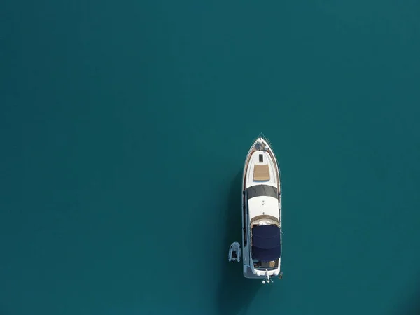 Aerial boat race. Luxury cruise trip. View from above of white boat on deep blue water. Aerial view of rich yacht sailing sea. Motor boat racing wave. Summer journey on luxury ship