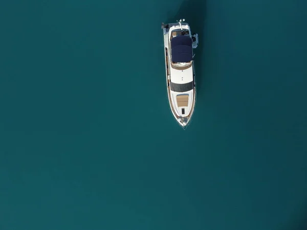 Aerial boat race. Luxury cruise trip. View from above of white boat on deep blue water. Aerial view of rich yacht sailing sea. Motor boat racing wave. Summer journey on luxury ship