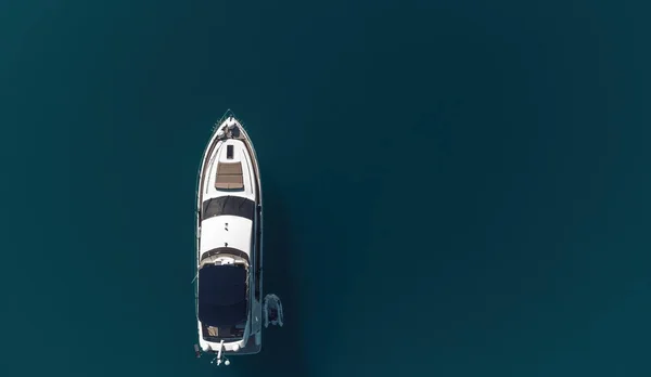 Aerial boat race. Luxury cruise trip. View from above of white boat on deep blue water. Aerial view of rich yacht sailing sea. Motor boat racing wave. Summer journey on luxury ship