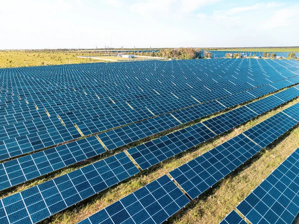 Aerial top view of a solar panels power plant. Photovoltaic solar panels at sunrise and sunset in countryside from above. Modern technology, climate care, earth saving, renewable energy concept