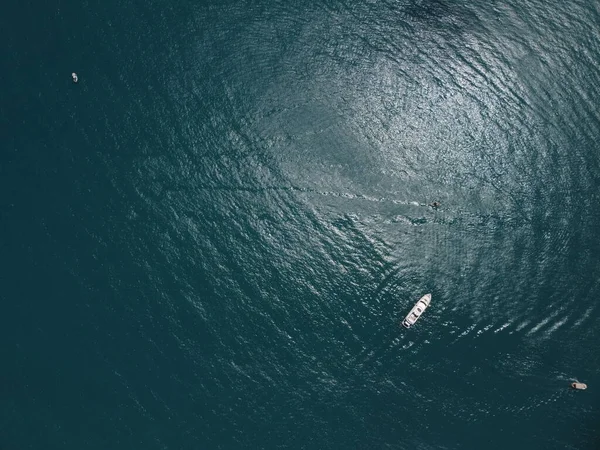 Aerial boat race. Luxury cruise trip. View from above of white boat on deep blue water. Aerial view of rich yacht sailing sea. Motor boat racing wave. Summer journey on luxury ship