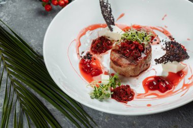 Tatlı soslu iştah açıcı sığır eti kapatın. Kiraz soslu sebze plaka ile sığır eti doğranmış. Lezzetli Avrupa mutfağı