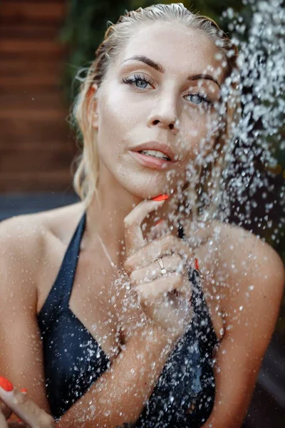 Γυναίκα με μαγιό που κάνει ντους κάτω από το νερό, πλύσιμο μαλλιών, καθαρισμό σώματος σε εξωτερικούς χώρους στο Luxury Spa Resort το καλοκαίρι. μοντέλο μόδας — Φωτογραφία Αρχείου
