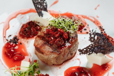 Tatlı soslu iştah açıcı sığır eti kapatın. Kiraz soslu sebze plaka ile sığır eti doğranmış. Lezzetli Avrupa mutfağı.