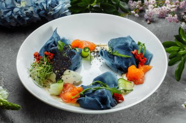 Tabakta tuzlanmış somon olan bir yığın krep. Somonlu mavi gözleme. Yararlı bir kahvaltı..