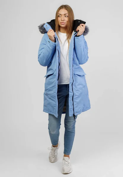 Fiatal nő téli ruhákban, fehér háttérrel. Fénykép koncepció a reklám a down kabát — Stock Fotó