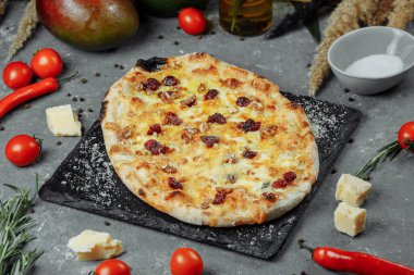 Sıcak dört peynir lezzetli ev yapımı Amerikan pizzası. Siyah masada kalın hamurlu..