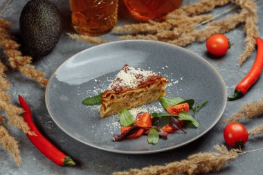Ev yapımı lezzetli et lazanyası, üstünde fesleğen yaprağı var. Kapatın. Yemek tarifi, menü. İtalyan mutfağı. Yan görünüm.