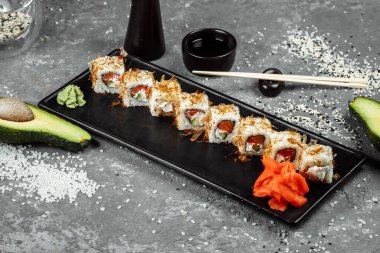 Krem peynirli suşi ruloları, kızarmış somon, ton balığı talaşı ya da kurutulmuş bonito, salatalık, nori. Çubuklar Japon restoranında taze katsuobushi rulosu tutuyor..