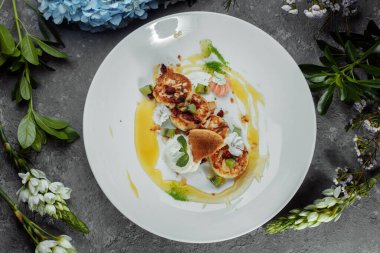 İdeal bir kahvaltı. Beyaz tabakta karamel, badem ve krem soslu süzme peynirli krep. Ukrayna şurubu.