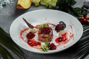 Tatlı soslu iştah açıcı sığır eti kapatın. Kiraz soslu sebze plaka ile sığır eti doğranmış. Lezzetli Avrupa mutfağı