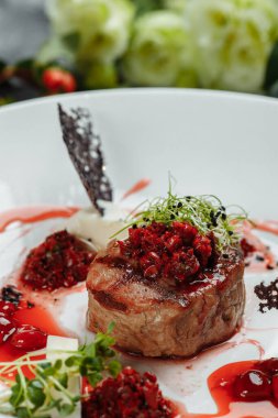 Tatlı soslu iştah açıcı sığır eti kapatın. Kiraz soslu sebze plaka ile sığır eti doğranmış. Lezzetli Avrupa mutfağı