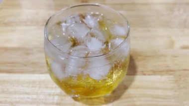 İçkiyle sodanın karıştırılmasıyla oluşan baloncuklar masanın üzerinde yenilenmeye ve dinlenmeye hazır bir şekilde duruyor. Yumuşak seçili odak