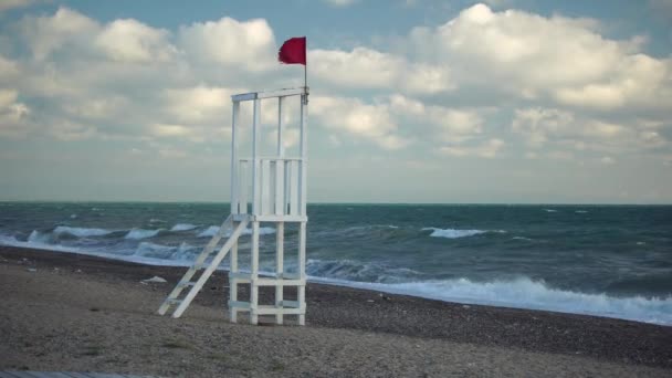 Witte houten strandwacht observatiepost op een zandstrand met golven. Het concept van eenheid met de natuur. — Stockvideo
