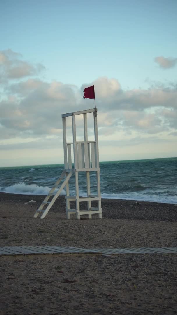 Weißer hölzerner Beobachtungsposten für Rettungsschwimmer an einem Sandstrand mit Wellen. Das Konzept der Einheit mit der Natur. — Stockvideo