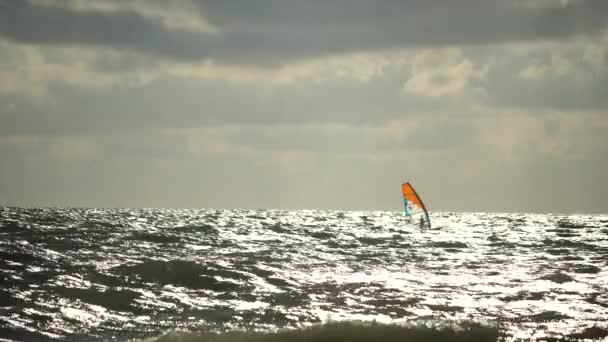 Kitesurf en las olas del mar esmeralda. El hombre está practicando kitesurf en el agua de mar turquesa. El hombre en el tablero flota rápidamente a través de las olas. Vacaciones de verano. — Vídeo de stock