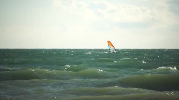 Kitesurfing on the waves of the emerald sea. The man is kiteboarding in the turquoise sea water. The man on the board quickly floats through the waves. Summer vacation. — Stock Video