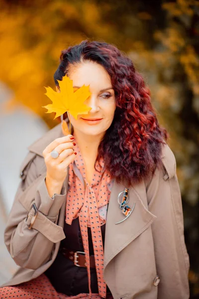 Hermosa chica caminando al aire libre en otoño. Chica sonriente recoge hojas amarillas en otoño. Mujer joven disfrutando del clima otoñal. —  Fotos de Stock