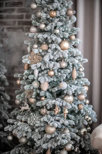 Primer plano de un árbol de Navidad al aire libre decorado festivamente con bolas sobre un fondo borroso y brillante. Luces de guirnalda desenfocadas, efecto bokeh. — Foto de Stock