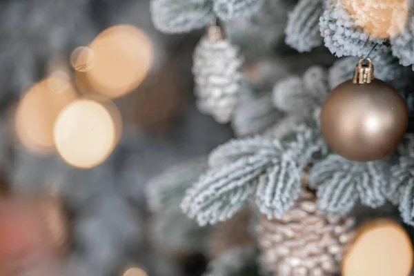 Close-up de uma árvore de Natal ao ar livre festivamente decorada com bolas em um fundo de fadas espumante borrado. Luzes de guirlanda desfocadas, efeito bokeh. — Fotografia de Stock