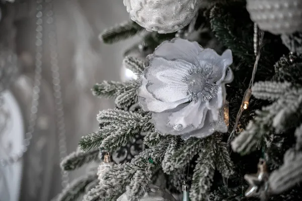 Närbild av en festligt dekorerad utomhus julgran med bollar på en suddig gnistrande älva bakgrund. Oskärpa körtelbelysning, bokeh effekt. — Stockfoto