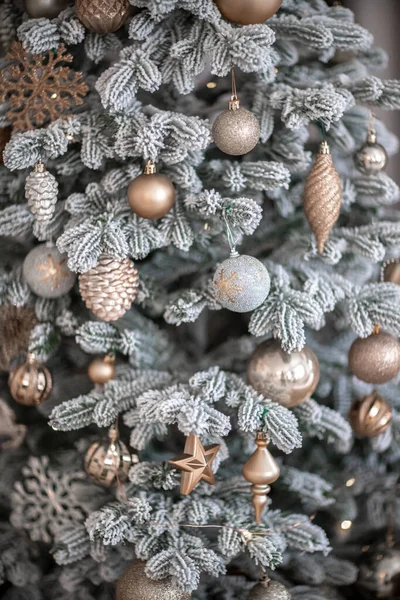 Primer plano de un árbol de Navidad al aire libre decorado festivamente con bolas sobre un fondo borroso y brillante. Luces de guirnalda desenfocadas, efecto bokeh. — Foto de Stock