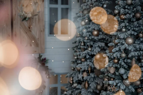 Close-up de uma árvore de Natal ao ar livre festivamente decorada com bolas em um fundo de fadas espumante borrado. Luzes de guirlanda desfocadas, efeito bokeh. — Fotografia de Stock