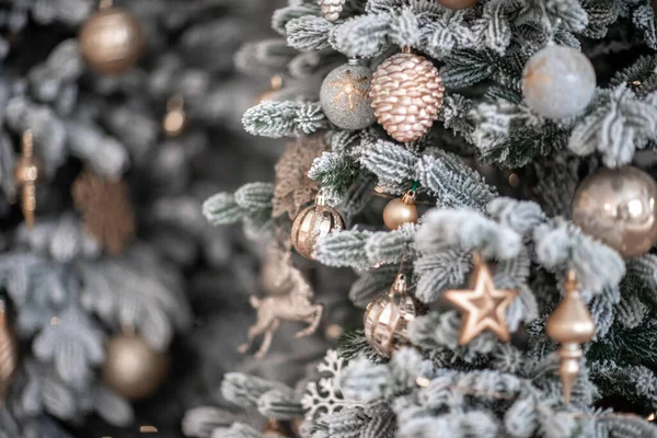 Close-up de uma árvore de Natal ao ar livre festivamente decorada com bolas em um fundo de fadas espumante borrado. Luzes de guirlanda desfocadas, efeito bokeh. — Fotografia de Stock