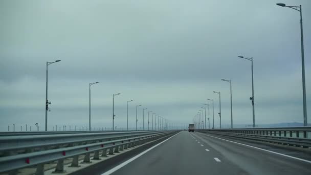 Samochód jadący szeroką pustą drogą wczesnym rankiem w pochmurną pogodę. Punkt widzenia kierowcy, widok wnętrza samochodu na autostradzie Autobahn — Wideo stockowe