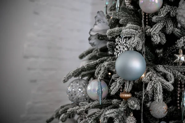 Close-up van een feestelijk versierde kerstboom met ballen op een wazig sprankelende sprookjesachtergrond. Defocused slinger lichten, bokeh effect. — Stockfoto