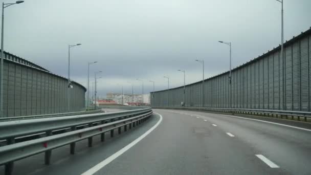 Um carro dirigindo ao longo de uma ampla estrada vazia no início da manhã em tempo nublado. Ponto de vista de condução, vista interior de um carro na Autobahn — Vídeo de Stock