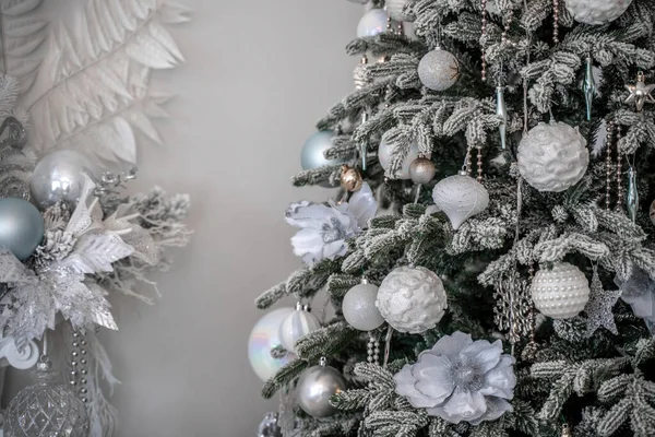 Primer plano de un árbol de Navidad al aire libre decorado festivamente con bolas sobre un fondo borroso y brillante. Luces de guirnalda desenfocadas, efecto bokeh. —  Fotos de Stock