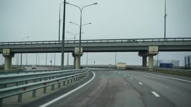 Samochód jadący szeroką pustą drogą wczesnym rankiem w pochmurną pogodę. Punkt widzenia kierowcy, widok wnętrza samochodu na autostradzie Autobahn — Wideo stockowe