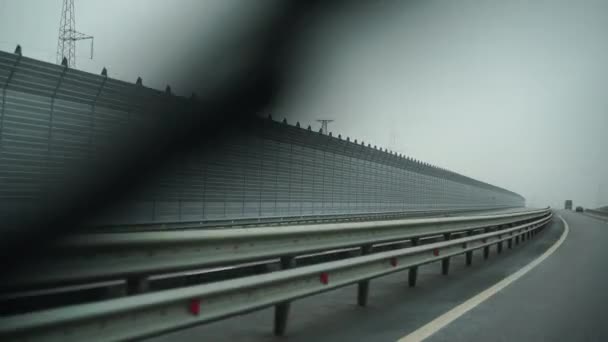 Een auto die vroeg in de ochtend over een brede lege weg rijdt bij bewolkt weer. Rijden standpunt, binnenaanzicht van een auto op de snelweg — Stockvideo